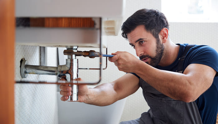 Handwerker arbeitet an einer Sanitärinstallation.